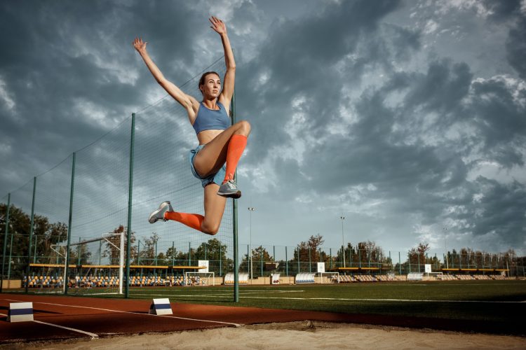 Female athlete performing a long jump during a competition