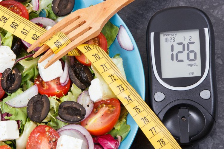 Glucose meter with sugar level, centimeter and greek salad