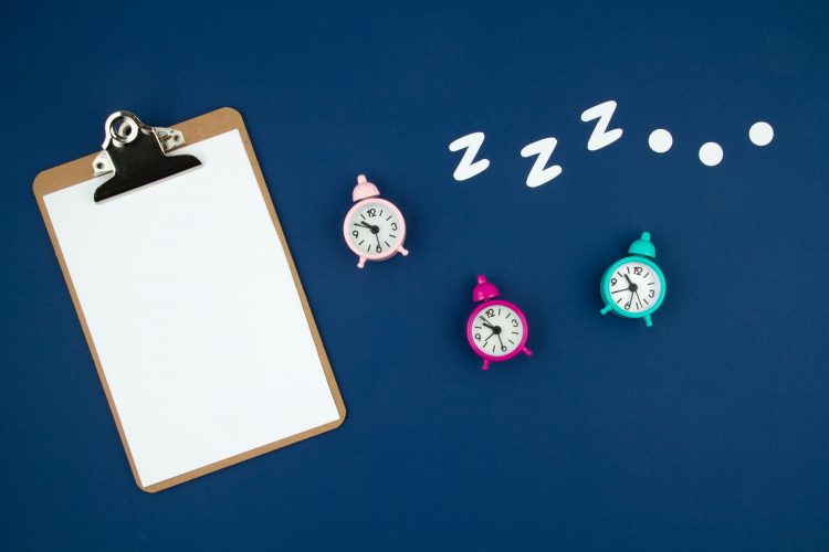 Snoring classic alarm clock on blue pastel trendy background. Flat lay, top view mock up