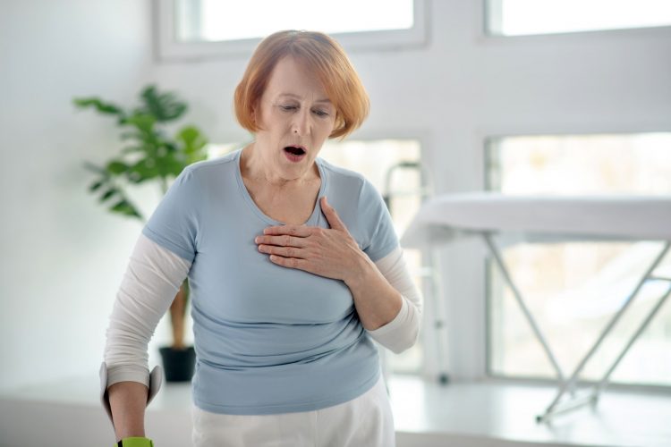 Cheerless red haired aged woman having health problems