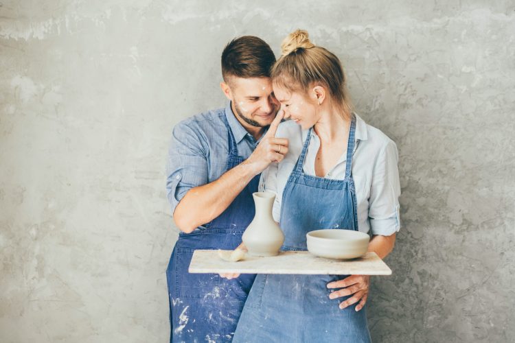 Couple in love working together in potter studio workshop.