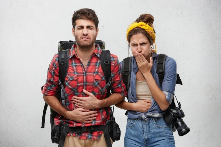 Food poisoning, nausea and sickness concept. Portrait of young man and woman tourists feeling stomac