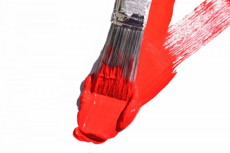 red paint on paper and paint brush on white paper