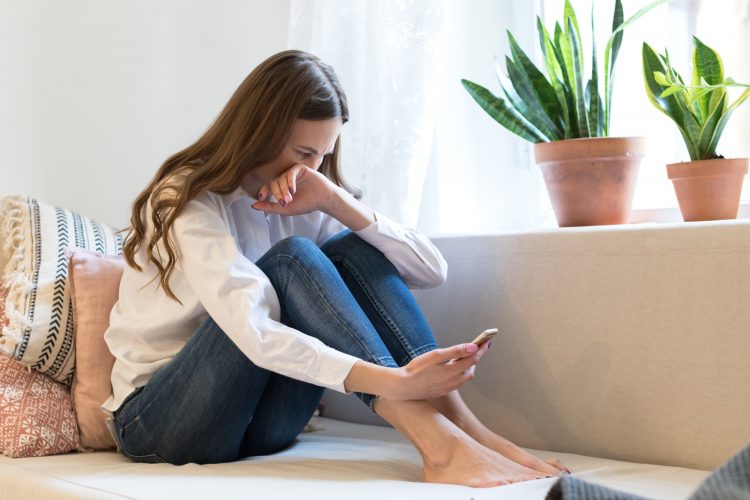 Upset woman cry read text message on smartphone suffer from breakup with boyfriend in tears on couch