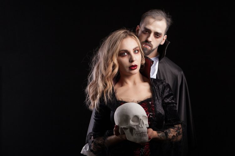 Portrait of seductive couple dressed up like vampires for halloween carnival