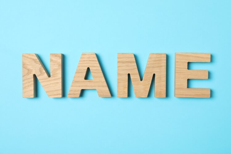 Word Name lined with wooden letters on color background