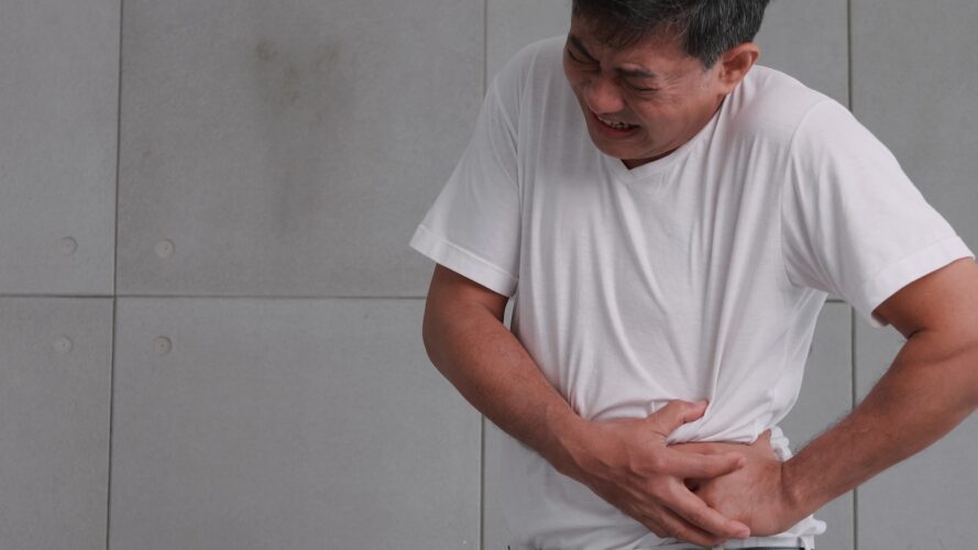 Asian man has severe stomach pains caused by appendicitis.