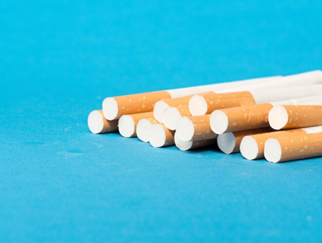 Closeup of tobacco cigarette filters on blue background