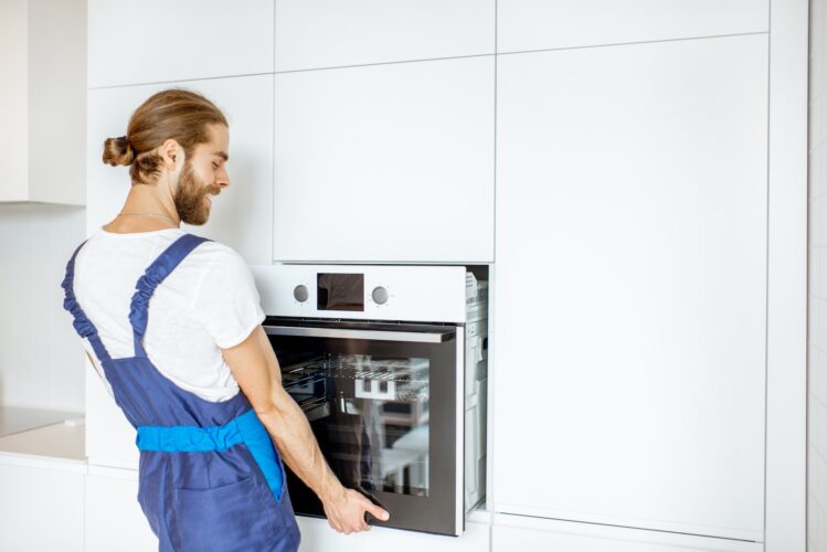 Workman installing kitchen oven