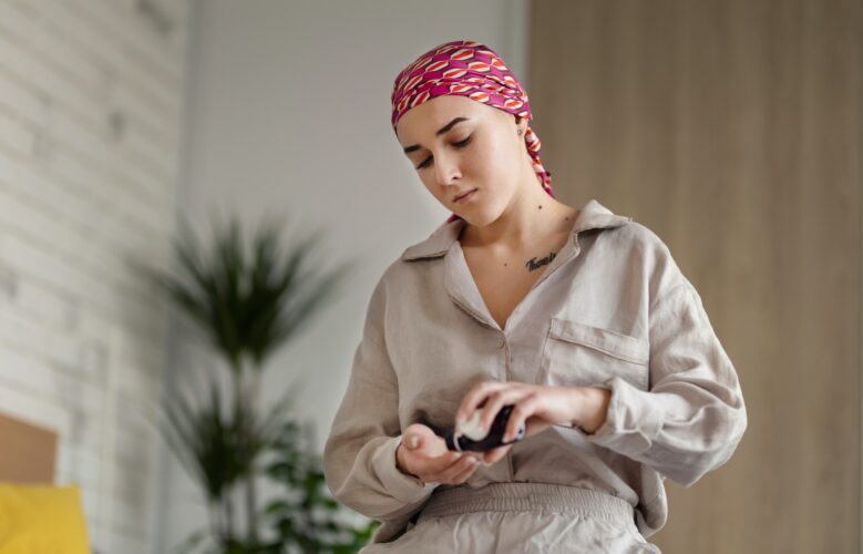 Young woman with cancer taking pills, cancer awareness concept.